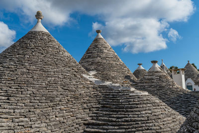 High section of trulli houses against cloudy sky