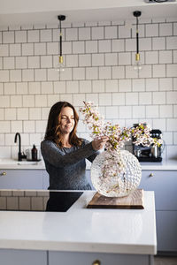 Woman arranging flowers in vase