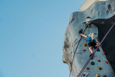 Low angle view of woman standing against clear sky