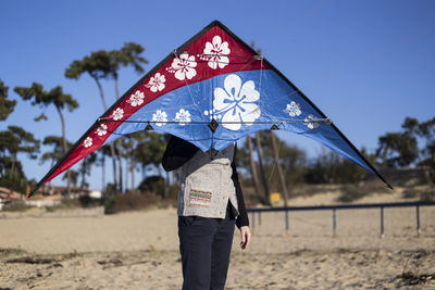 Man holding kite on beach