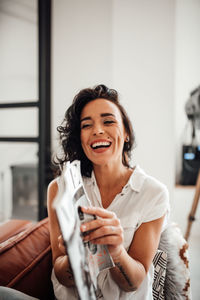 Smiling young woman sitting at home