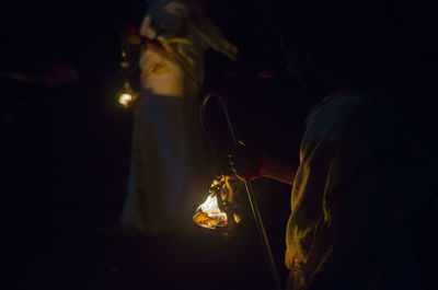 People carrying burning containers at night