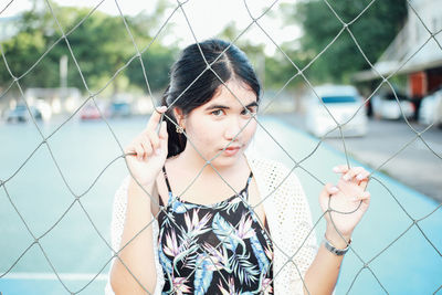 Portrait of woman seen through net in court