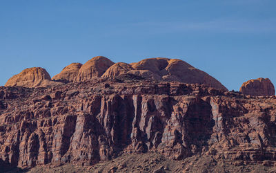 Full frame low angle view of sandstone cliffs against a blue sky