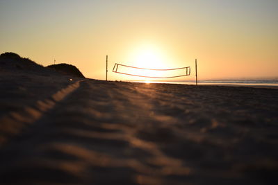 Surface level of beach against sky during sunset