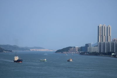 Boats in sea against clear sky