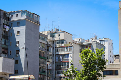 Low angle view of buildings against clear blue sky