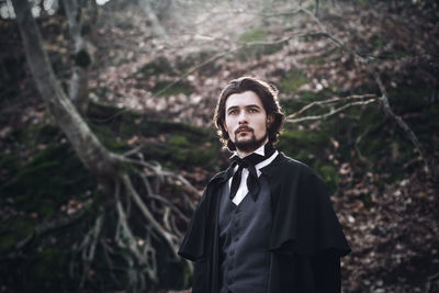 Portrait of man in period costume standing outdoors