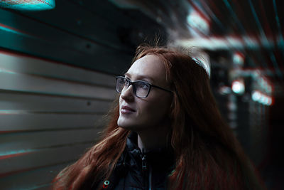 Close-up of smiling young woman looking away in corridor