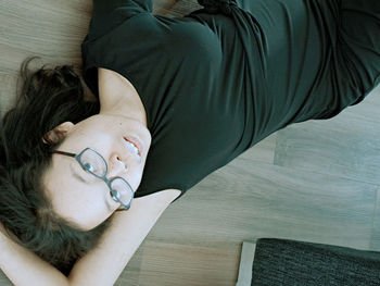 High angle view of woman relaxing on hardwood floor at home