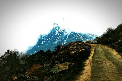 Road leading towards mountains against sky