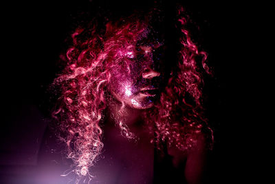 Portrait of woman against black background