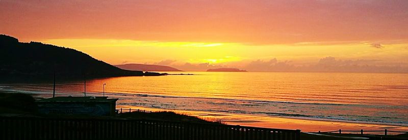 Scenic view of sea against orange sky