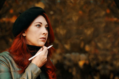 Portrait of young woman smoking cigarette outdoors