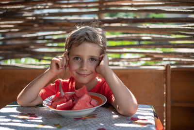 Portrait of boy having watermelon in plate at table