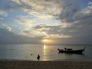 Silhouette boat in sea against sky during sunset