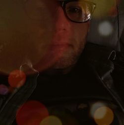 Close-up portrait of man holding eyeglasses