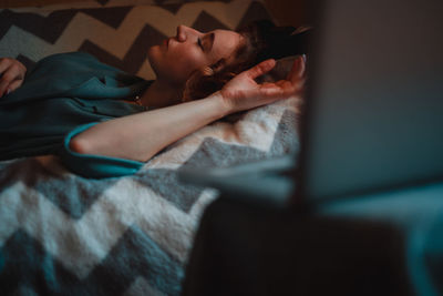 High angle view of young woman sleeping on bed at home