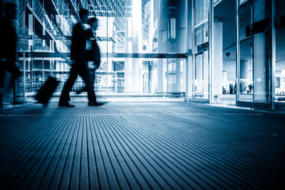 People walking on footpath amidst buildings in city