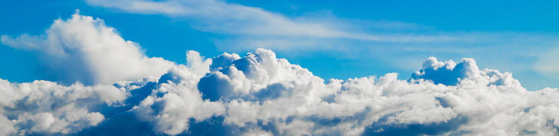 Beautiful fluffy clouds on a clear blue sky. banner format. background for design.