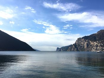 View of calm blue sea against mountain range