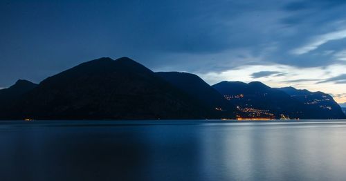 Scenic view of lake and mountains against blue sky