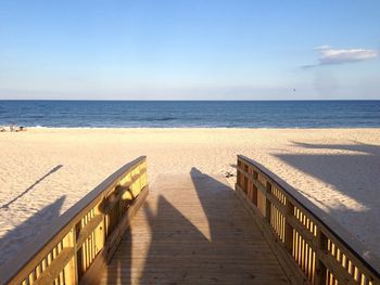 Pier at beach against sky