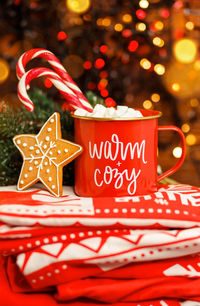 Christmas cappuccino in red mug on red blanket. christmas decorations