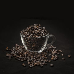 Close-up of coffee beans on table against black background