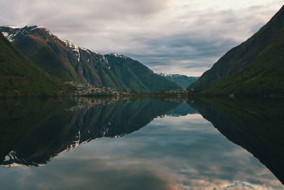 Scenic view of lake by mountains against sky