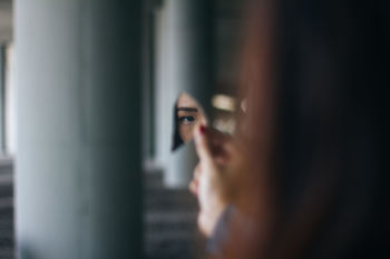 Cropped image of woman reflecting in broken glass