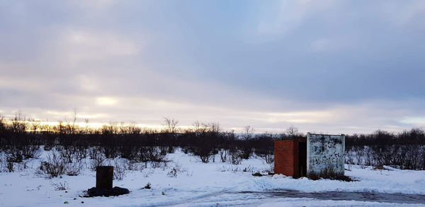 Scenic view of snow covered field against sky