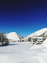 Scenic view of snowcapped mountains against clear blue sky