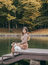 Woman sitting on bench by lake