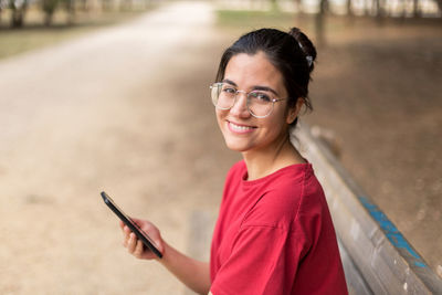 Portrait of smiling woman using mobile phone