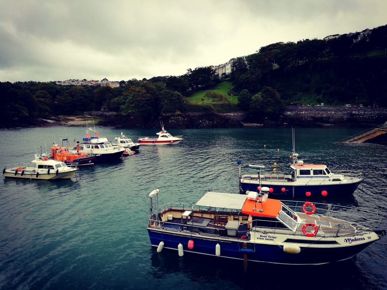 BOATS MOORED IN SEA AGAINST SKY