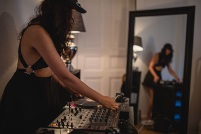 Fashionable young woman playing music at home