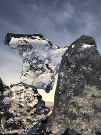 Snow on rock against sky