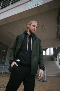 Full length of young man standing against wall