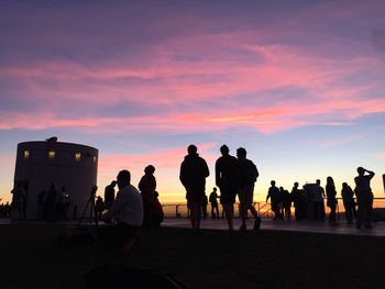 Silhouette people standing against sky during sunset