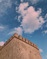 Low angle view of old building against cloudy sky