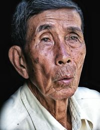 Close-up portrait of woman against black background