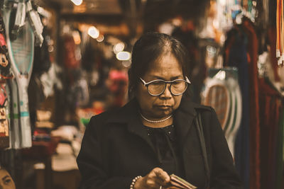 Senior woman wearing eyeglasses standing in market