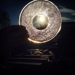 Close-up of illuminated lighting equipment against sky