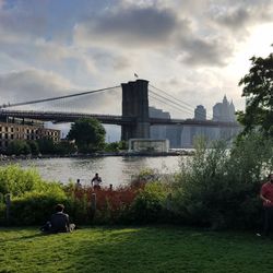 Bridge over river against cloudy sky