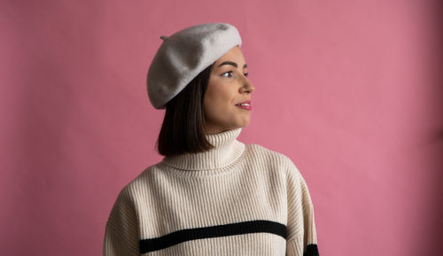 Portrait of young woman standing against yellow background