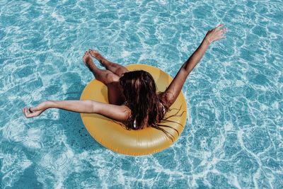 High angle view of woman lying on swimming pool