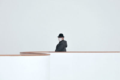 Rear view of man standing against white background