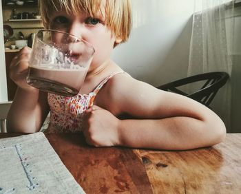 Close-up of girl drinking hot chocolate at home