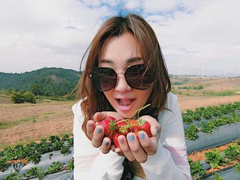 Portrait of young woman holding strawberries